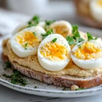 Eggs with hummus on toast served with avocado and fresh herbs